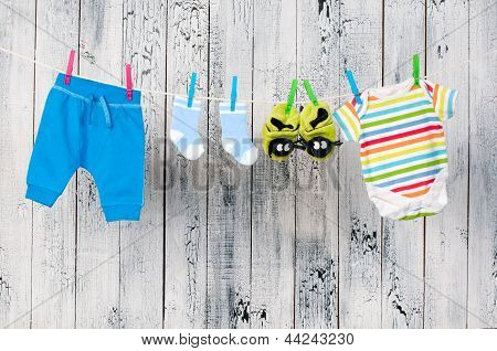 Детская одежда висит на веревках.
