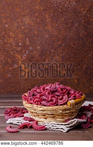 Dry Traditional Beetroot Pasta. Wooden Background. Top View.