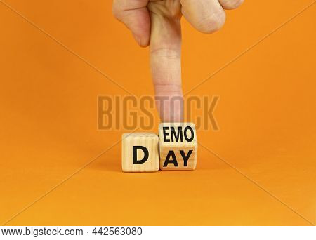Demo Day Symbol. Businessman Turns A Wooden Cube With Concept Words 'demo Day' On A Beautiful Orange