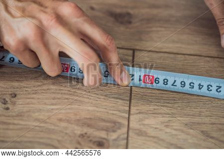 Man Installing New Wooden Laminate Flooring On A Warm Film Floor. Infrared Floor Heating System Unde