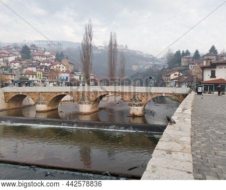 Sarajevo, Bosnia And Herzegovina - December 16, 2020: Old Stone Seher Cehaja Bridge Over Miljacka Ri