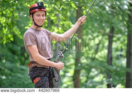 Man Belays His Partner Climber With Belaying Device And Rope. Climbers Handsman Holding Equipment Fo