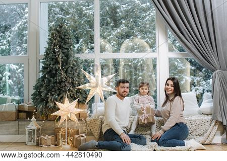 Happy Family Of Mom, Dad And Little Daughter Spent Time Together On The Eve Of Christmas. Young Pere
