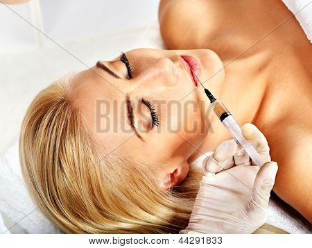 Doctor woman giving facial injections. Isolated.