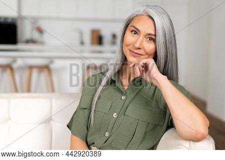 Close-up Portrait Of Charming Middle-aged Woman With Long Silver Hair Sitting In Relaxed Athmosphere