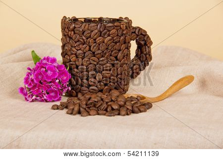 Cup from coffee grains and bright carnation