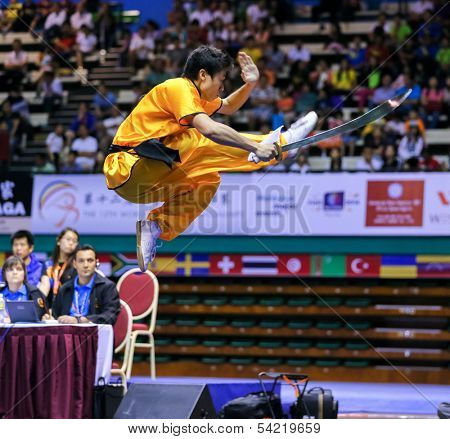 KUALA LUMPUR - NOV 03: Brazil's Henry Yuji Nakata executes a high kick in the Men's 'Daoshu' Event at the 12th World Wushu Championship on November 03, 2013 in Kuala Lumpur, Malaysia.
