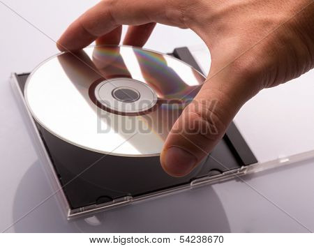hand taking DVD disc from box.