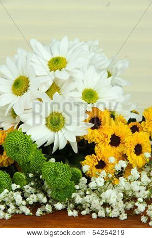Beautiful flowers on table on wooden background