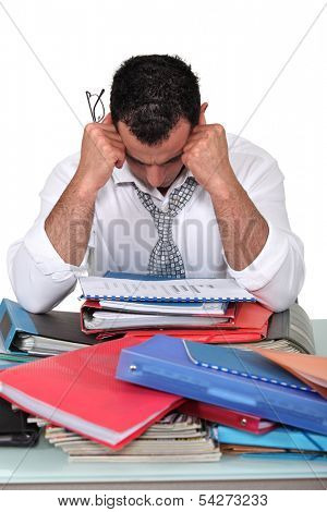 Depressed businessman surrounded with paperwork
