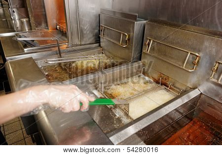 Deep fryers with boiling oil on fast food kitchen