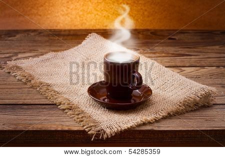 Coffee cup and saucer on  wooden table.