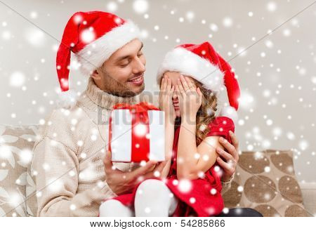 family, christmas, x-mas, winter, happiness and people concept - smiling daughter with closed eyes waiting for a present from fathe