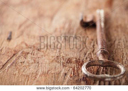 large and small rusty vintage metal keys on old wooden background, shallow dof
