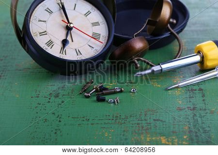 Repair clock on wooden background