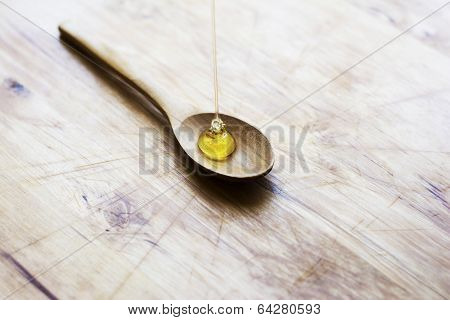 Honey Dripping Into Wooden Spoon