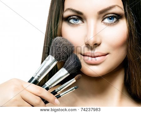 Beauty Girl with Makeup Brushes. Natural Make-up for Brunette Woman with Brown Eyes. Beautiful Face. Makeover. Perfect Skin. Applying Makeup 