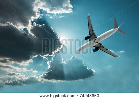 Airplane at flying under sky with clouds