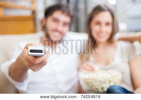 Couple using a remote control while sitting on the couch