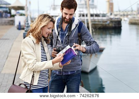 tourist couple with guide book on vacation