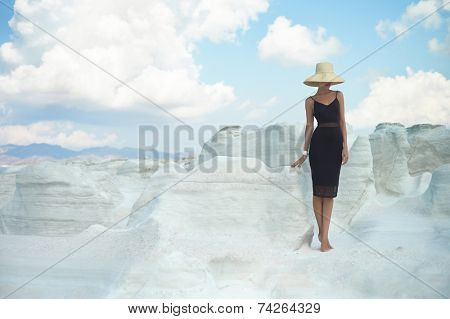 Fashion photo of beautiful lady in hat in an unusual landscape