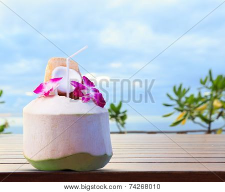 Green Coconut And Orchid Flowers As Welcome Drink In Tropical Destination Place On Top Wood Table Ag