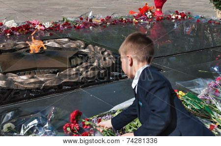 Schoolboy Put Flowers To The Eternal Fire At The Memorial