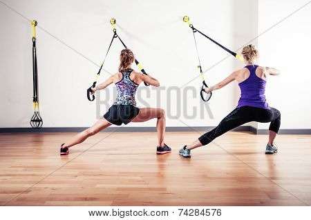 Two Women Working Out With Straps