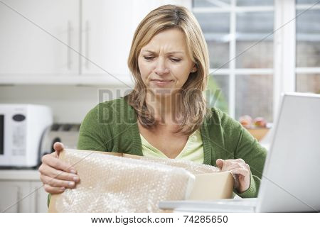 Disappointed Woman Unpacking Online Purchase At Home