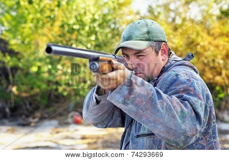 Hunter Taking Aim At The Target. Hunter With A Gun.