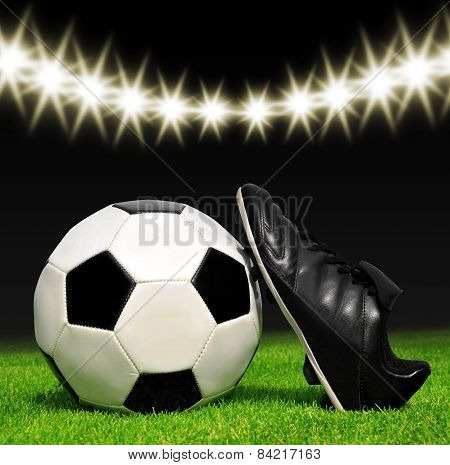 Soccer ball and shoes in grass
