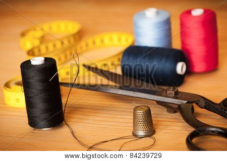 Vintage Background With Sewing/sewing Kit. Scissors, Bobbins With Thread And Needles On The Old Wood