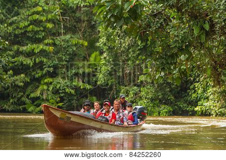 Cuyabeno, Ecuador - 20 March 2015: European Biologists In The Canoe Crossing Cuyabeno River Looking Straight Into The Camera, South America In Cuyabeno On March 20, 2015