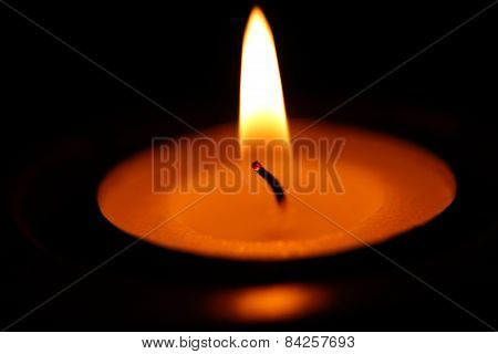 Candle on dark background.