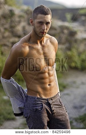 Handsome Young Man Takes Off His Shirt