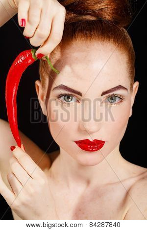 Sexy brunette girl with red cayennes isolated on black