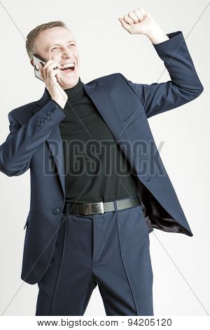 Expressive Handsome Caucasian Man In Elegant Siut Speaking By Cell Phone And Smiling