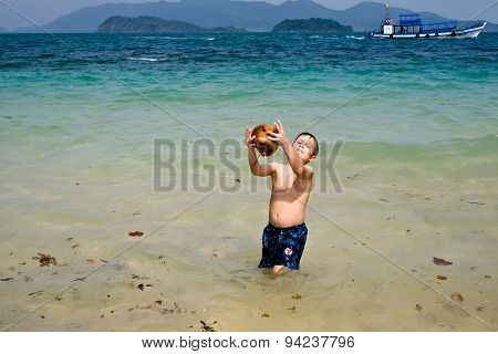 Boy Is Playing With A Coconut On A Beautiful Beach