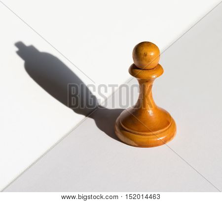 a chess pawn casting a king piece shadow concept of strength and aspirations