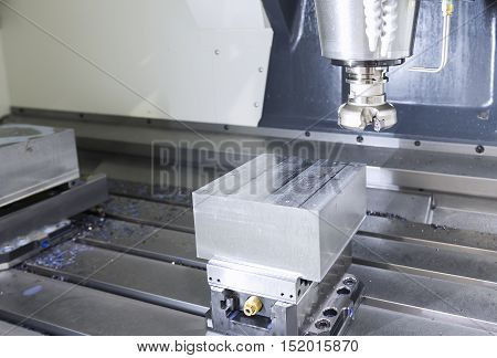 The face milling tool with the raw material work piece on the CNC milling machine.The spindle with holder and tooling for face milling on CNC milling machine