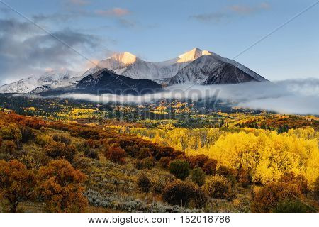 Sunrise at Twin mountain View of Mount Sopris and Mount Elk with Fall color and morning mist Snowmass Maroon Bells Wilderness area Colorado