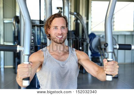 Man training hard at fitness gym. Man doing workout on fitness machine at gym. Gym trainer athlete working out chest muscles doing strength training exercises on gym benchpress equipment.