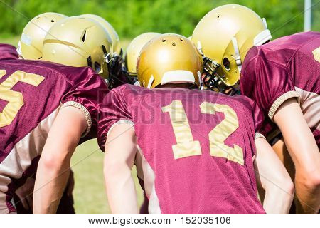 American Football players at strategy huddle