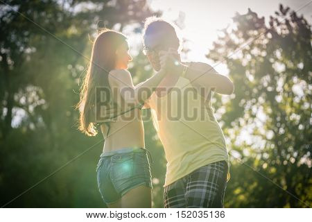 Mann turning woman while dancing Bachata in the sun