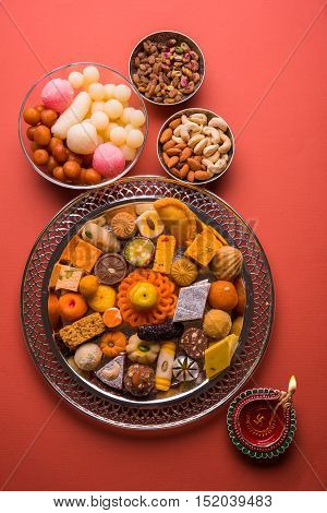 Mix Mithai and diya on diwali over colourful background