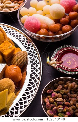 Mix Mithai and diya on diwali over colourful background