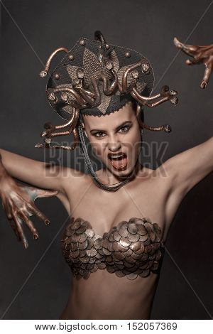 girl Medusa headdress of gold color on a black background.