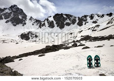 Snowshoes In Snow Mountains In Sun Spring Day