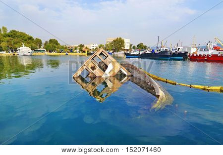 sunken boat reflected on water at Eleusis Greece