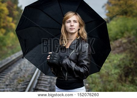 Girl, Umbrella And Rails In Autumn Day